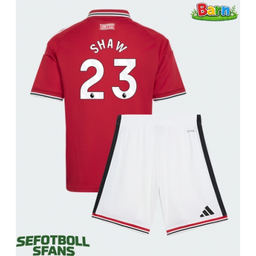 Manchester United Luke Shaw #23 Hemmaställ Barn 2026-27 Kortärmad (+ Korta byxor) Manchester United Luke Shaw #23 Hemmaställ Barn 2026-27 Kortärmad (+ Korta byxor)